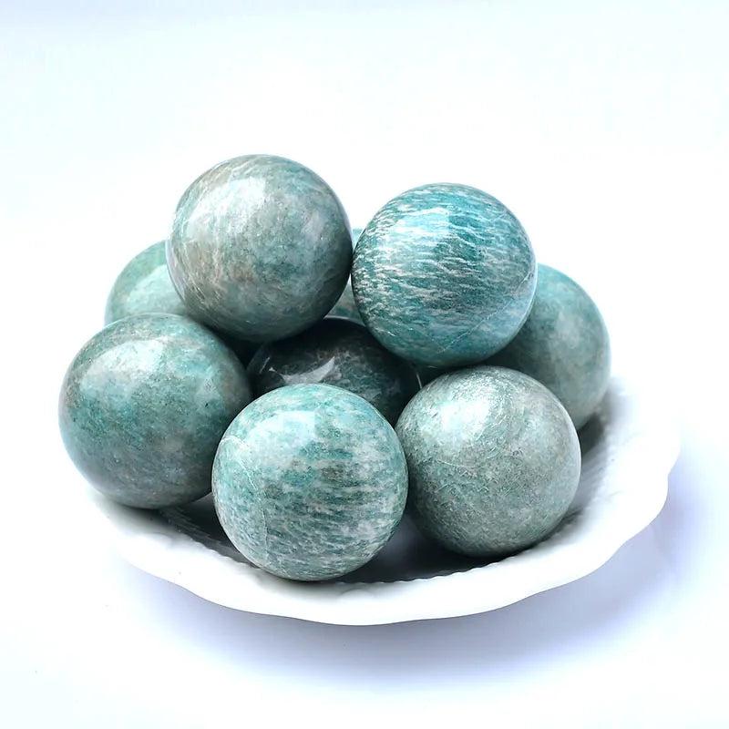 Polished natural Amazonite spheres in varying shades of blue-green, ideal for reiki healing and home decor.