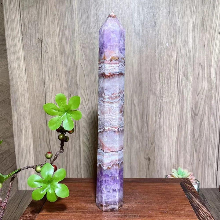 Tall, slender natural amethyst tower with purple and white bands, ideal for healing and home decor.