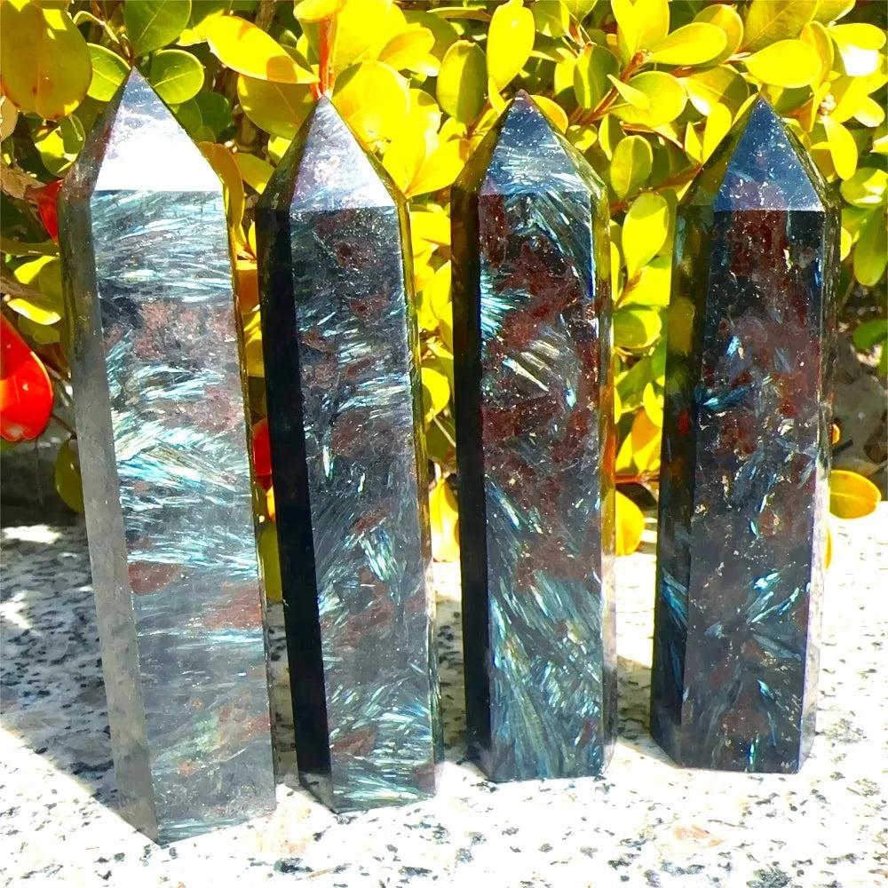 Four polished Natural Astrophyllite Towers with Arfvedsonite Flash, showcasing dark matrix, golden-bronze blades, and electric blue-green flashes.
