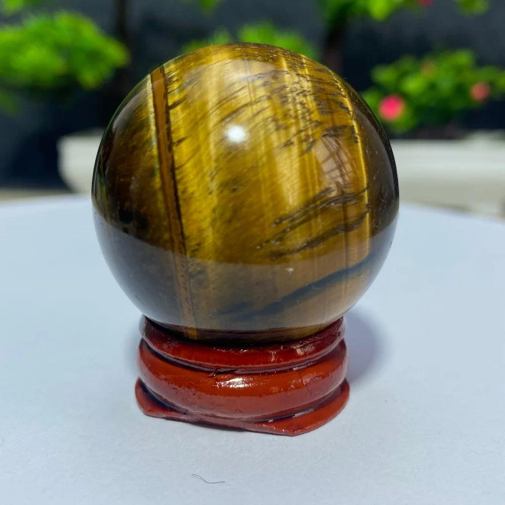 Polished natural Tiger Eye crystal ball on a wooden stand, perfect for Reiki healing, meditation, and spiritual home decor.