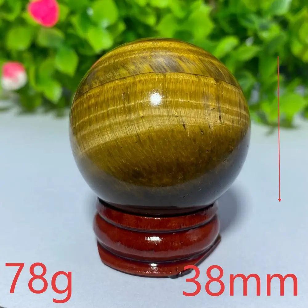 38mm natural yellow Tiger Eye crystal ball on a wooden stand, perfect for Reiki healing, meditation, and home decor.