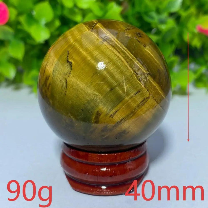 Polished 40mm yellow tiger eye crystal ball on a wooden stand, perfect for Reiki healing, meditation, and home decor.