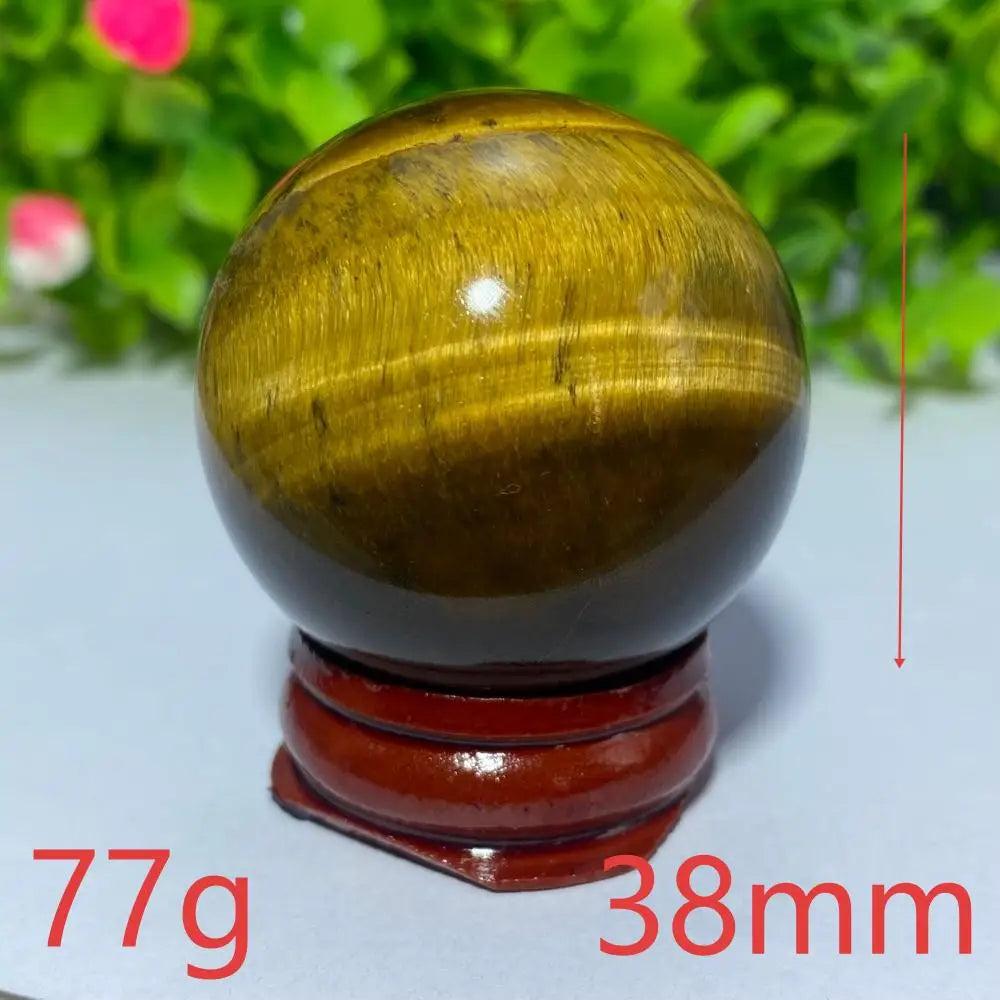 38mm natural yellow Tiger Eye crystal ball on a wooden stand, perfect for Reiki healing, meditation, and home decor.