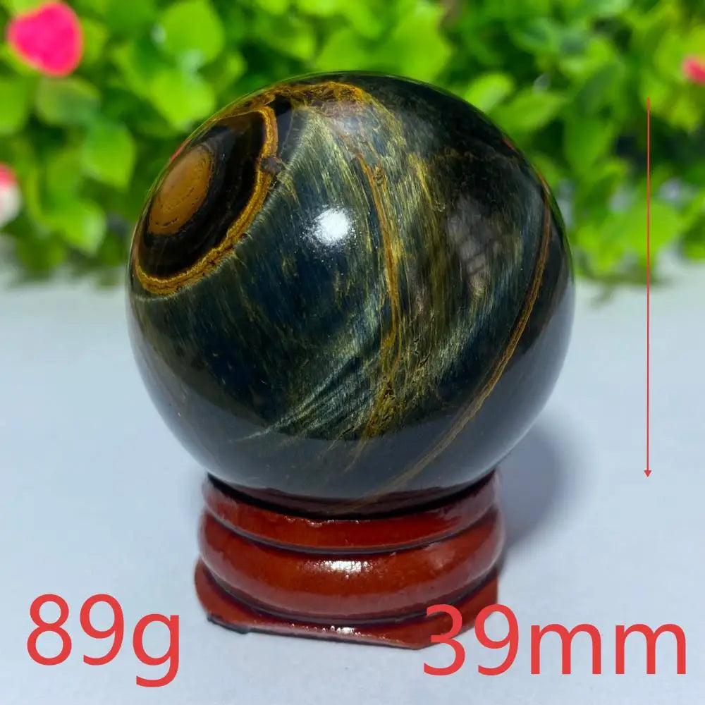 39mm Blue and Yellow Tiger Eye crystal ball on a wooden stand, perfect for Reiki healing, meditation, and home decor.