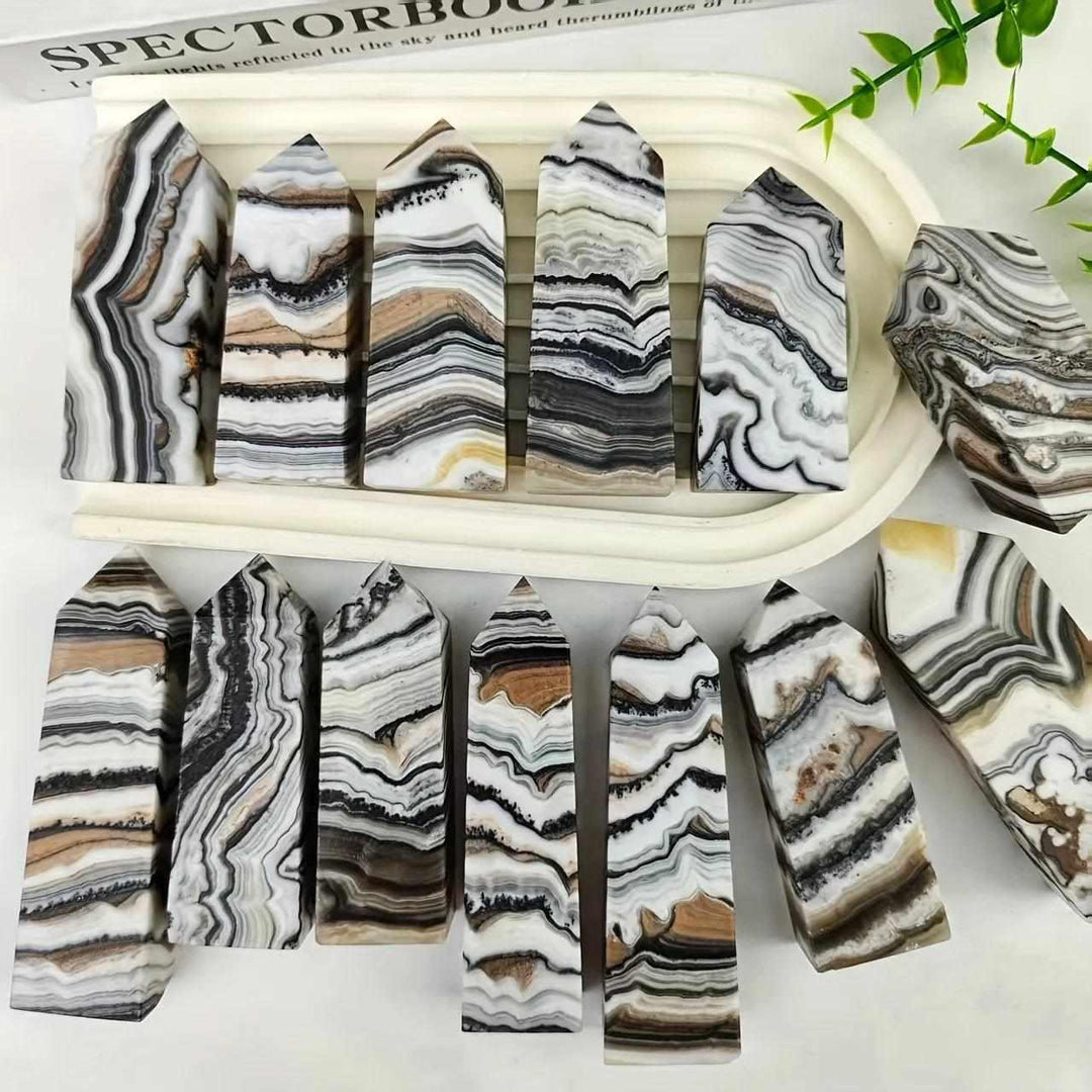 Polished chocolate calcite crystal towers featuring earthy brown, black, and white bands for grounding root chakra energy.