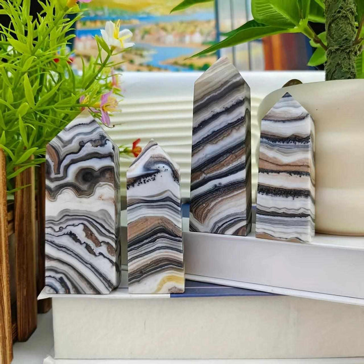 Polished chocolate calcite crystal towers with earthy, banded brown and white patterns for grounding root chakra energy.