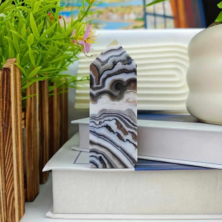 Polished chocolate calcite crystal tower featuring earthy, banded brown and white swirls for grounding root chakra energy.