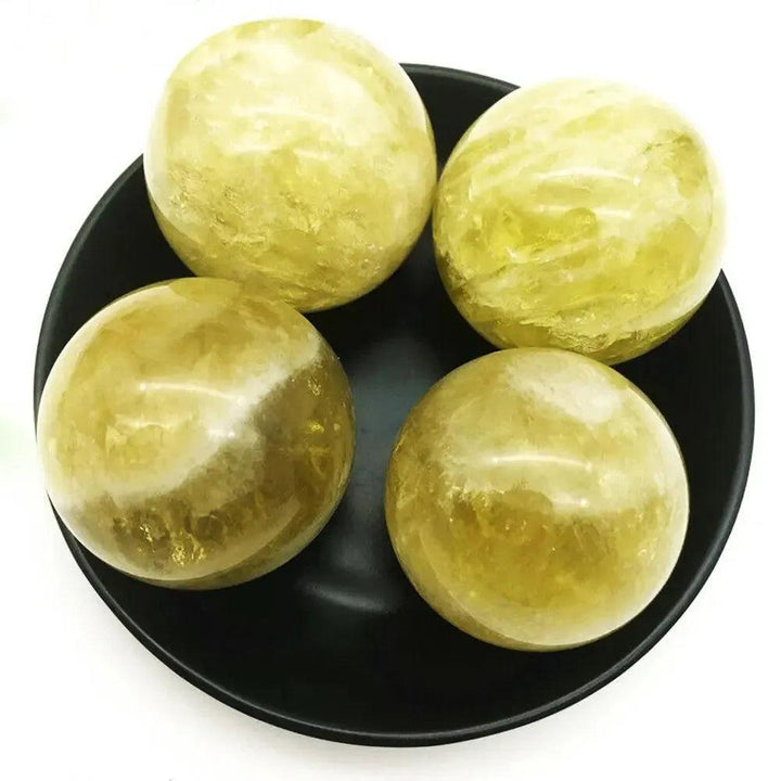 Four polished Natural Citrine Quartz Spheres from Crystal Destiny, radiating warm golden-yellow hues for abundance and joy.