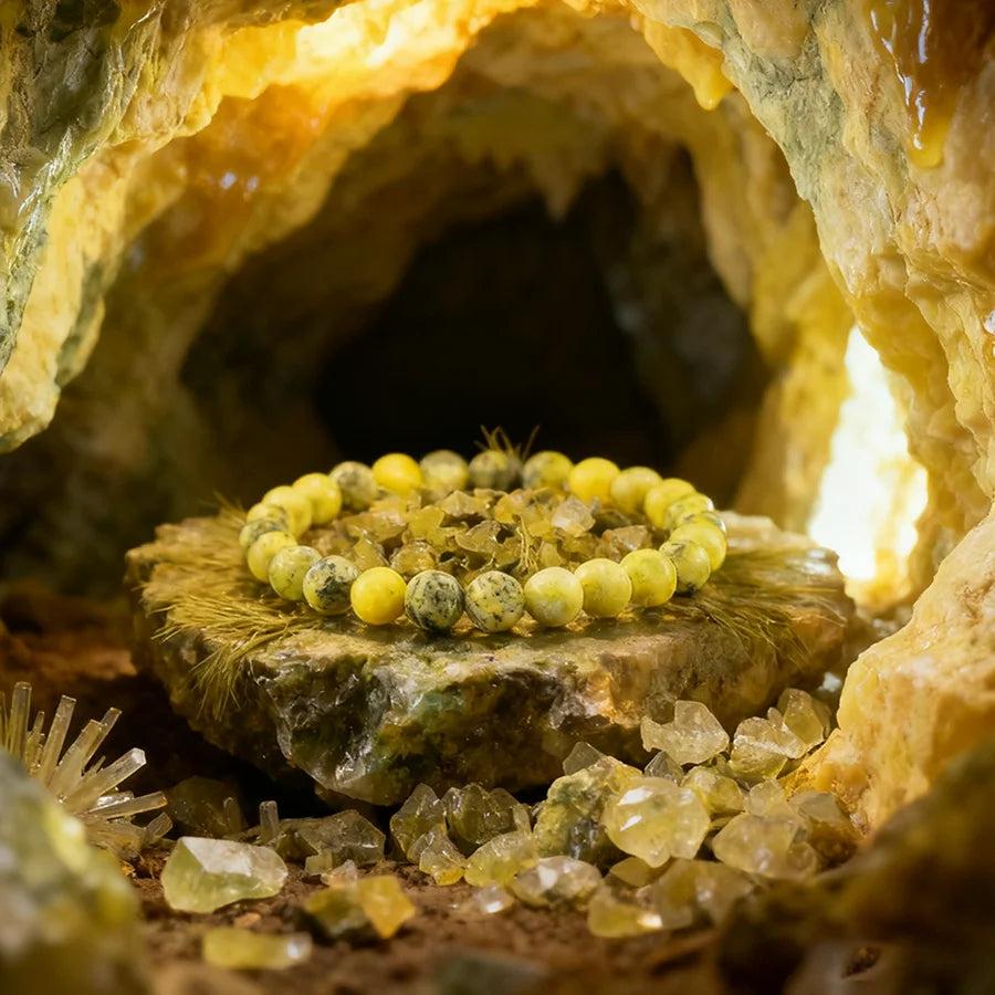 Original Tree Agate Bracelet with natural yellow-green beads, promoting healing and spiritual balance, displayed in a crystal cave.
