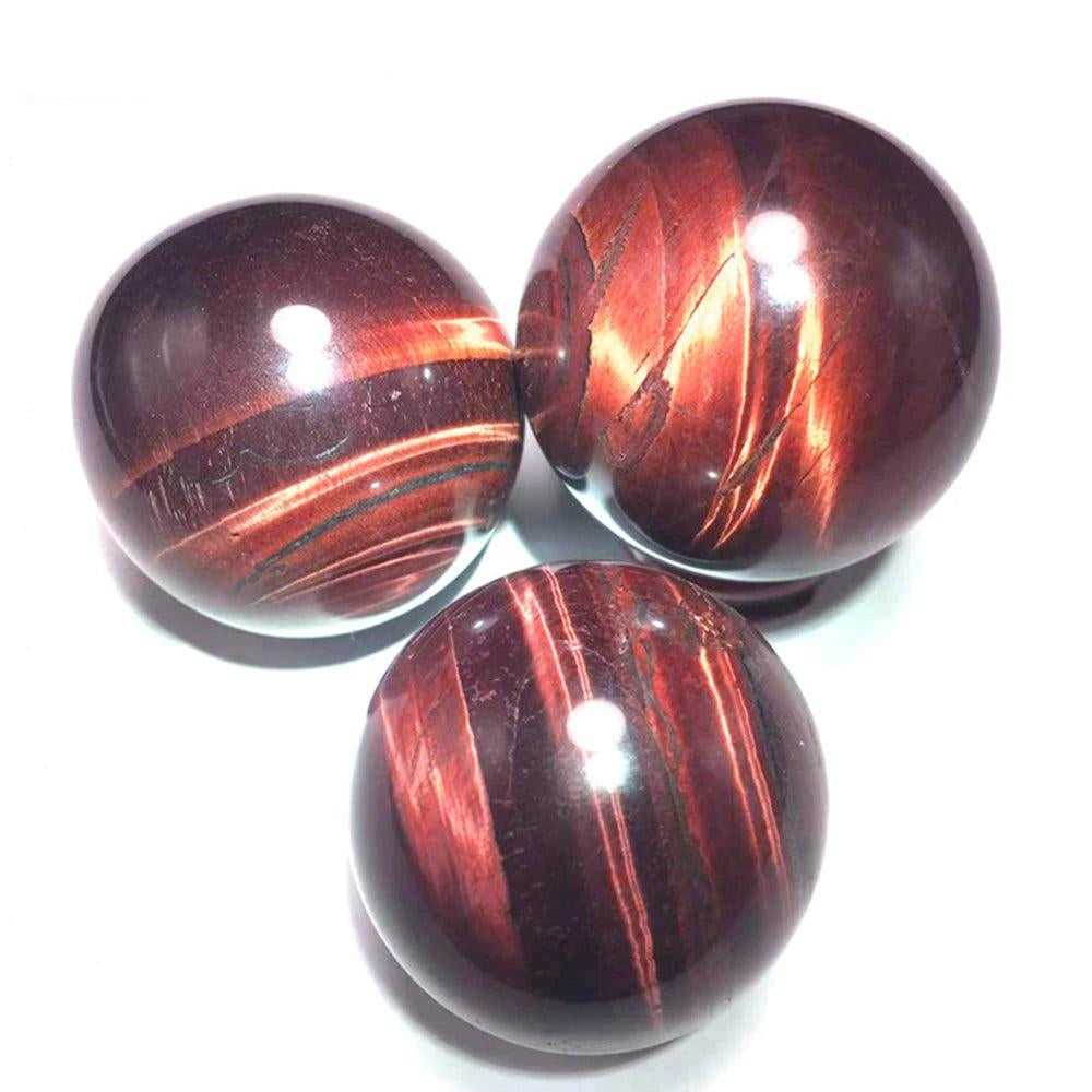 Polished Red Tiger Eye crystal balls with deep crimson hues for Reiki healing, divination, and elegant home decor.