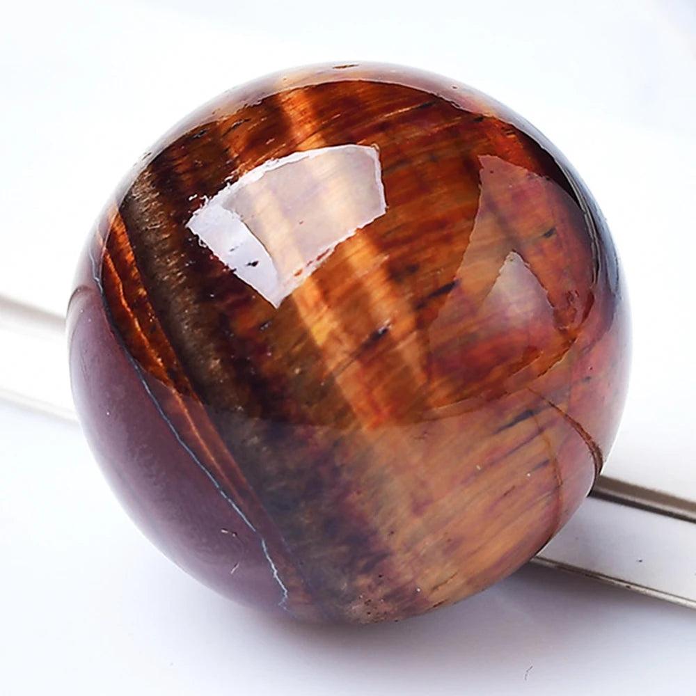 Polished Red Tiger Eye crystal ball with rich, swirling amber tones for Reiki healing, divination, and home decor.