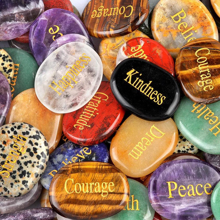 Assorted natural crystal oval palm stones, polished smooth with gold-filled engraved inspirational words like "Courage" and "Peace.