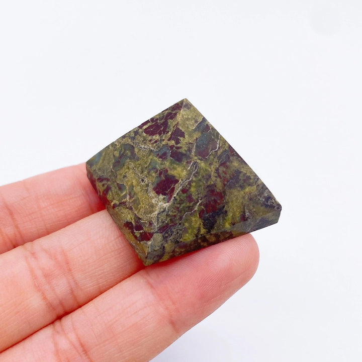 Dragon Blood Stone pyramid, 30mm, with deep green and red patterns, held in a hand.
