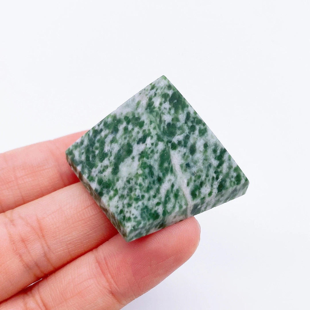 Green Spot Jade crystal pyramid, 30mm, held in hand, for healing and meditation.