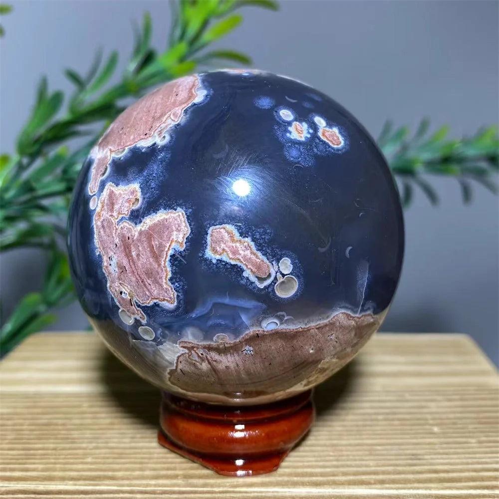 Natural dark blue and brown agate sphere on a wooden stand, resembling a globe.