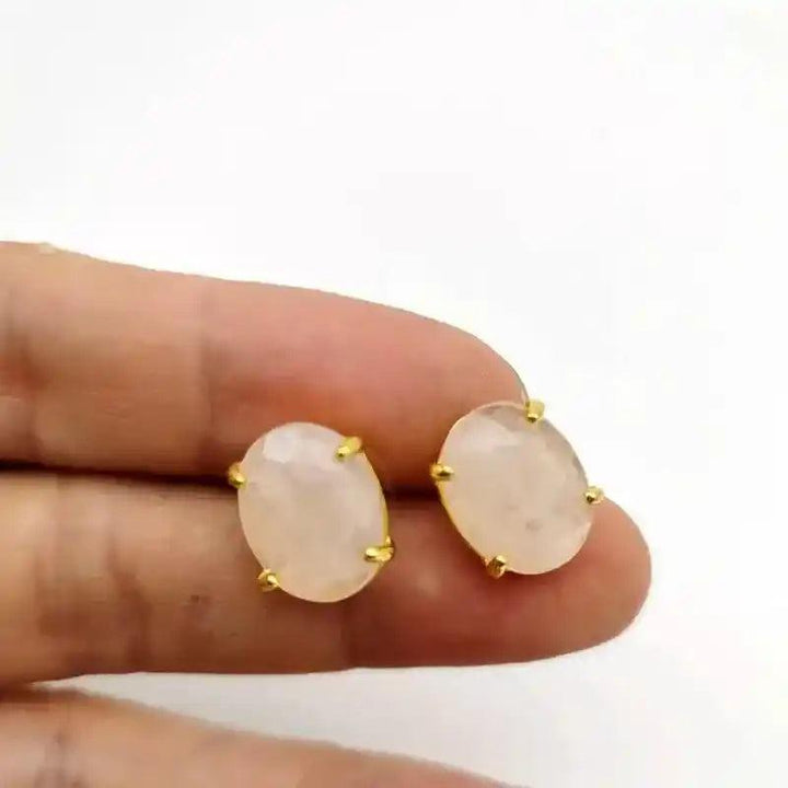 Elegant oval pink quartz stud earrings in gold-tone settings, radiating love and compassion.