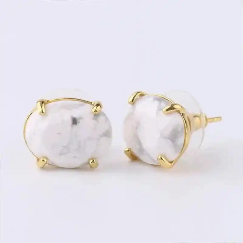 Elegant white marble-patterned oval stud earrings in a gold-tone setting, offering clarity and wisdom.