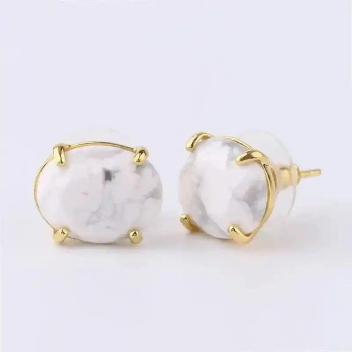 Elegant white marble-patterned oval stud earrings in a gold-tone setting, offering clarity and wisdom.