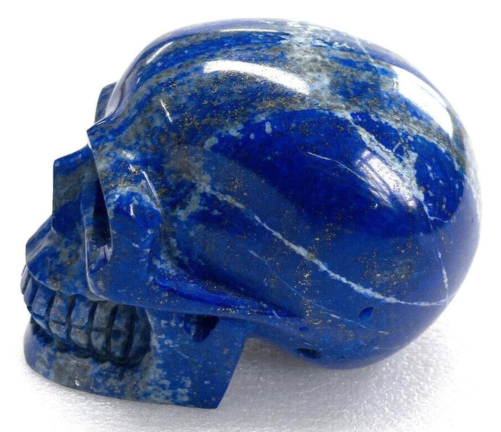 Polished natural Lapis Lazuli crystal skull with deep blue hues and gold pyrite flecks for healing and Feng Shui decor.