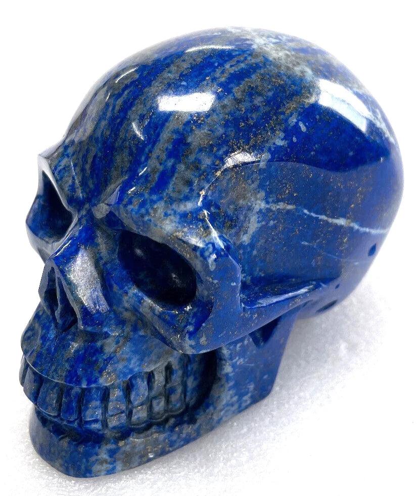 Polished Lapis Lazuli crystal skull with deep blue hues and gold flecks, perfect for Feng Shui and spiritual healing.