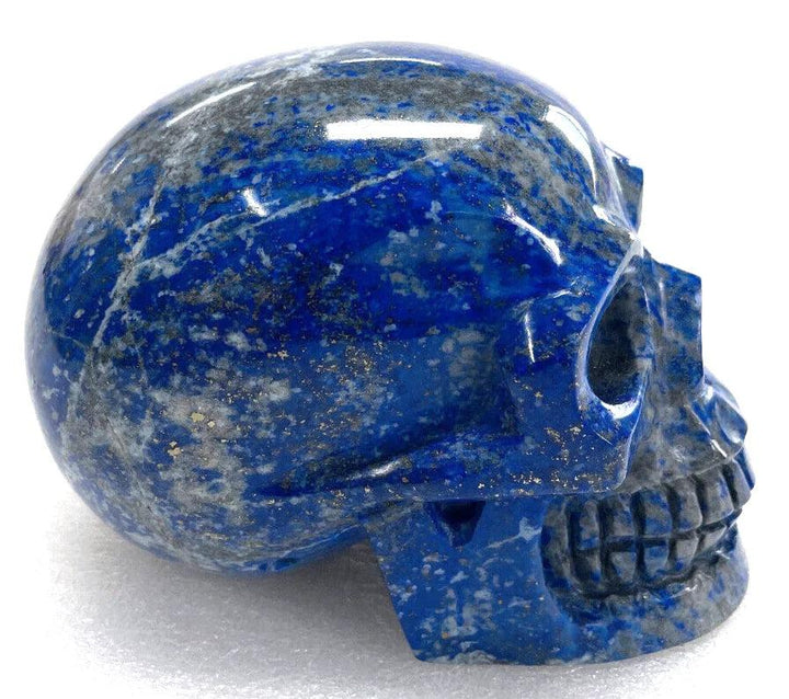 Polished Lapis Lazuli crystal skull with deep blue hues and gold pyrite flecks for healing and Feng Shui decor.