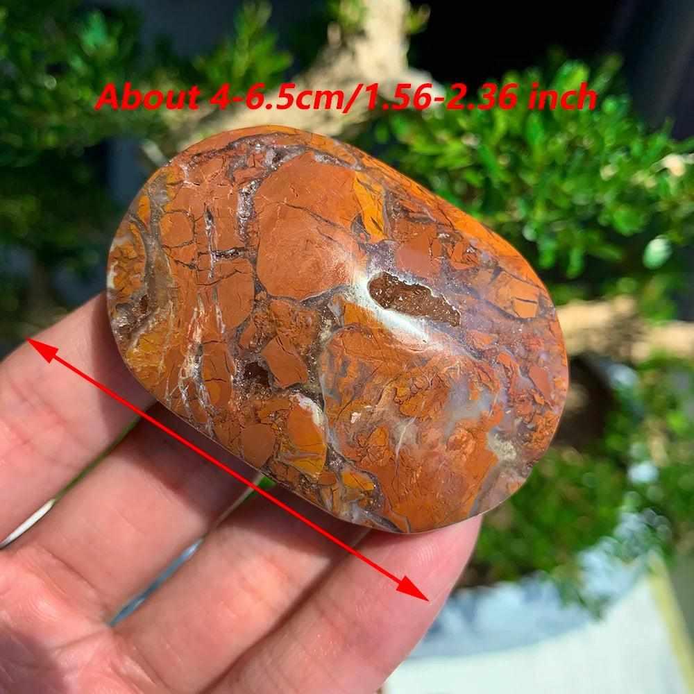 Polished Maligano Jasper palm stone with swirling rust, tan, and cream patterns for grounding and meditation.