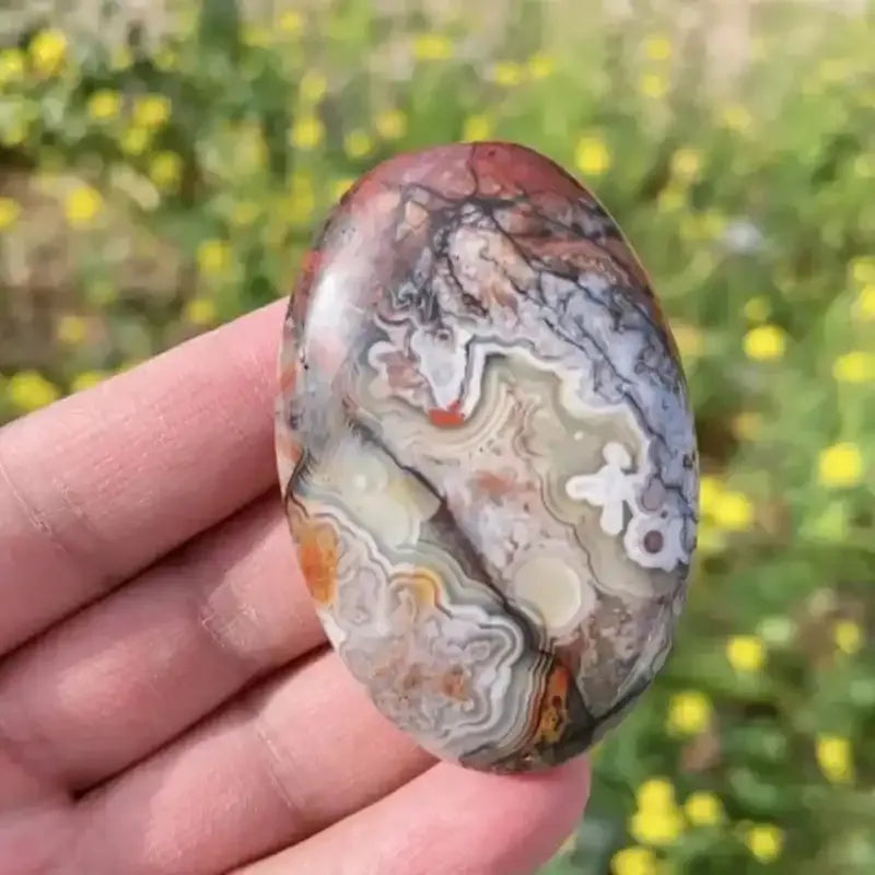 Polished natural Mexican Red Agate palm stone featuring intricate, swirling earthy patterns for healing and home decor.