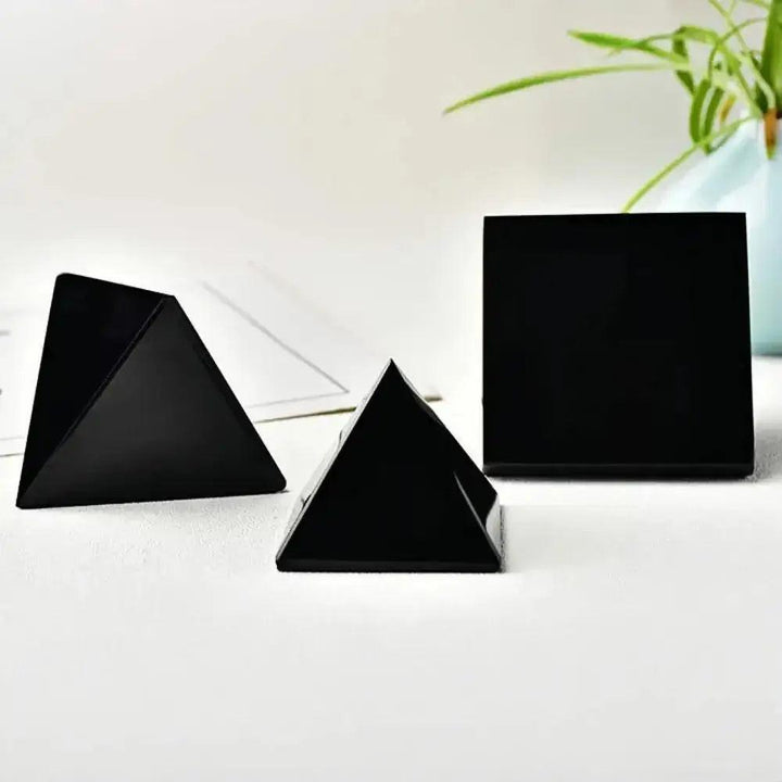 Smooth, jet-black Natural Obsidian Pyramids from Crystal Destiny, ideal for grounding and protection.