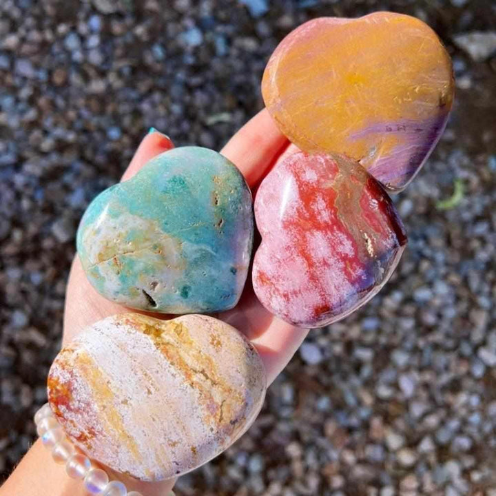 Polished Ocean Jasper heart crystals in vibrant green, pink, and tan orb patterns for heart chakra healing and joy.