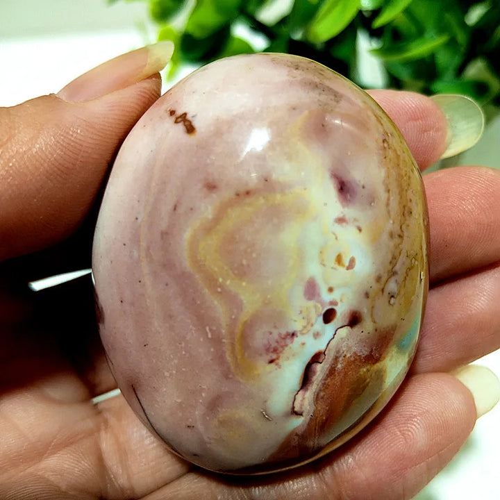 Polished polychrome jasper palm stone featuring earthy rust, cream, and sage bands for grounding meditation energy.