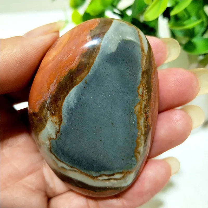 Polished polychrome jasper palm stone with rust, cream, and sage bands for grounding meditation and chakra balancing.
