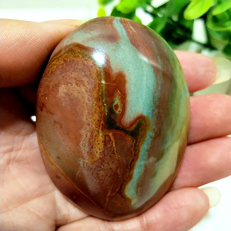 Polished polychrome jasper palm stone with earthy rust, cream, and sage bands for grounding meditation and chakra healing.