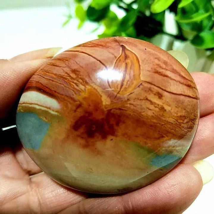 Polished polychrome jasper palm stone with earthy rust, cream, and sage bands for grounding and chakra meditation.