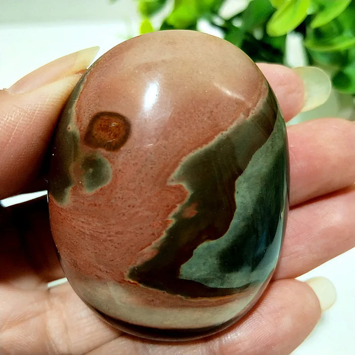 Polished polychrome jasper palm stone featuring earthy bands of rust, cream, and sage for grounding meditation energy.