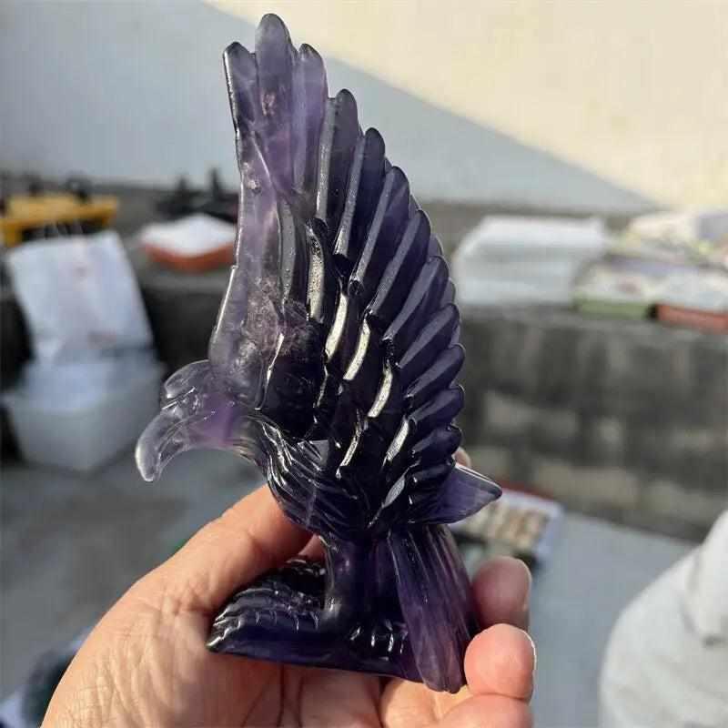 Natural purple fluorite eagle figurine with deep violet banding, carved for Third Eye chakra clarity and intuition.