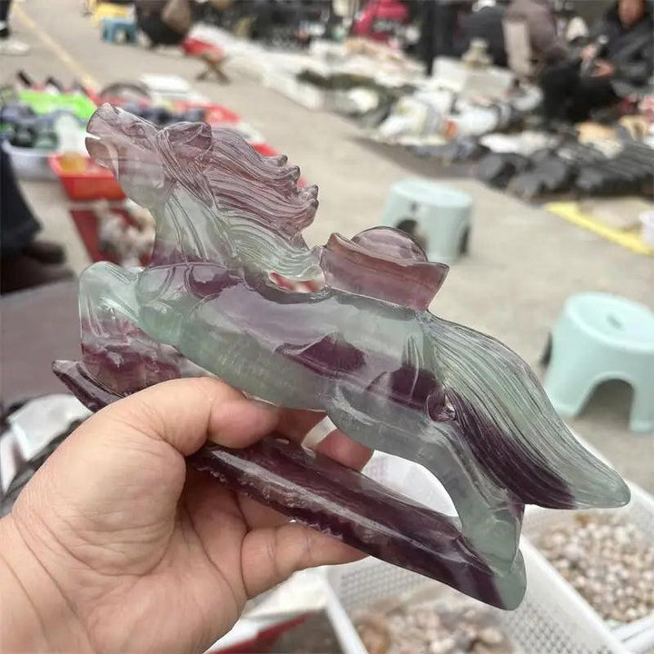 Hand-carved rainbow fluorite horse figurine featuring vibrant purple and green crystal banding for mental clarity.