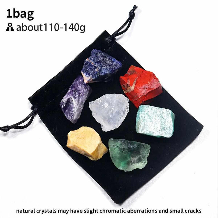 Natural raw 7 chakra crystal healing kit featuring seven colorful, textured stones in a black velvet drawstring pouch.