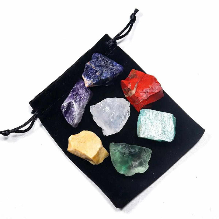 7 Chakra healing kit with raw, natural crystals for grounding and spiritual balance on a black velvet drawstring pouch.