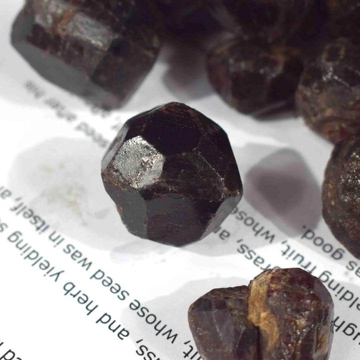 Rough, dark red natural Garnet crystal, a faceted raw gemstone mineral for healing and spiritual gifts.