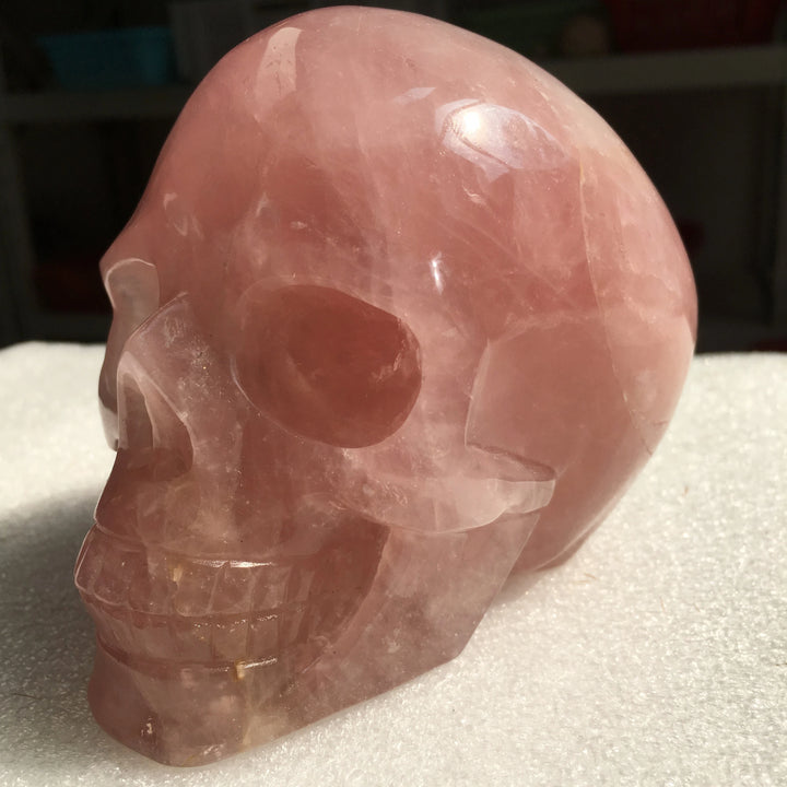 Hand-carved rose quartz crystal skull with a polished pink finish, perfect for Reiki healing and elegant home decor.