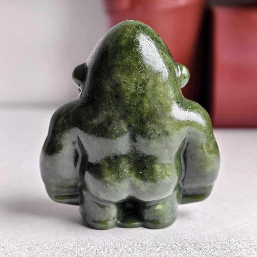 Polished natural serpentine crystal gorilla sculpture in deep olive green, offering grounded energy for your altar.
