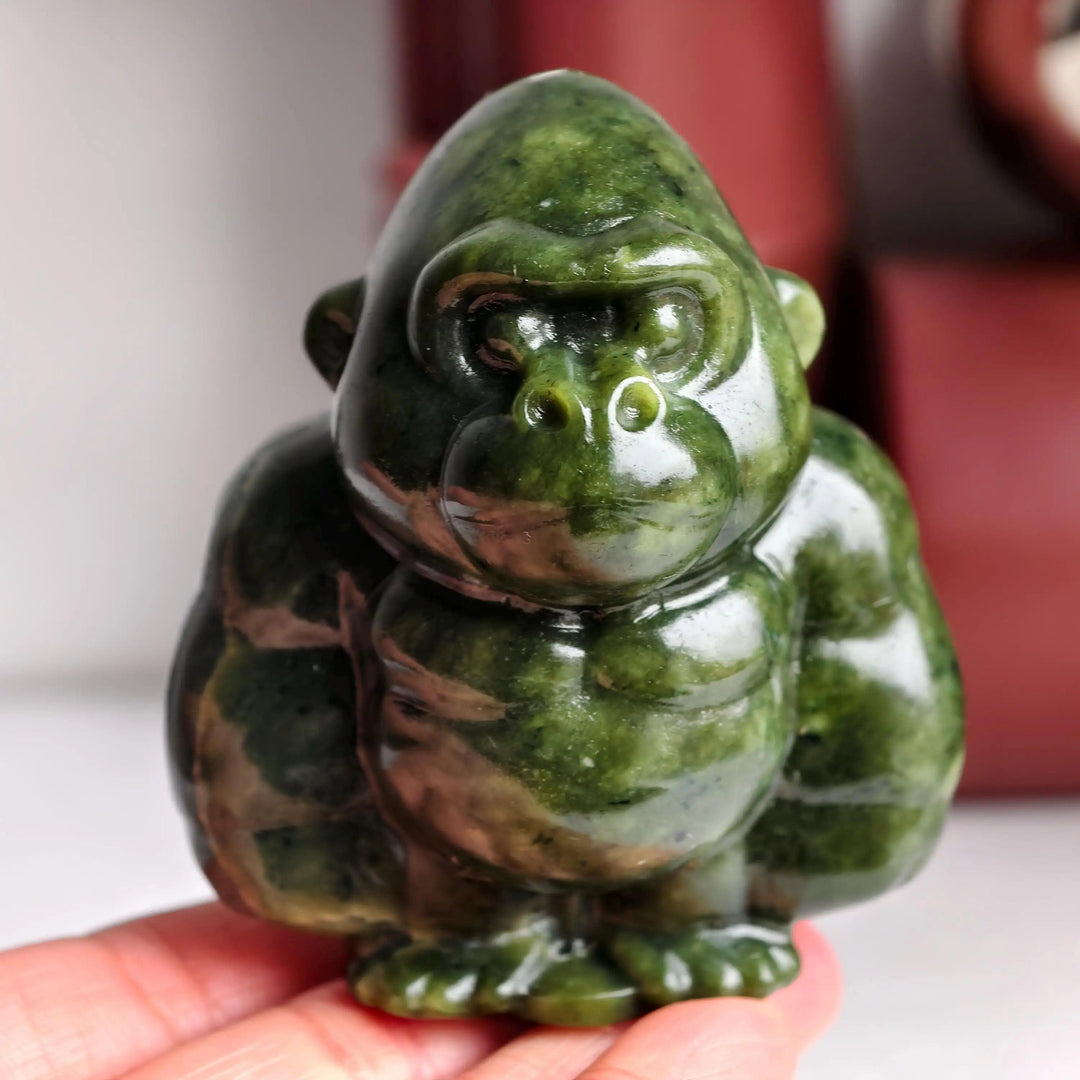 Polished natural serpentine gorilla sculpture in deep olive green, offering grounded energy for your meditation space.
