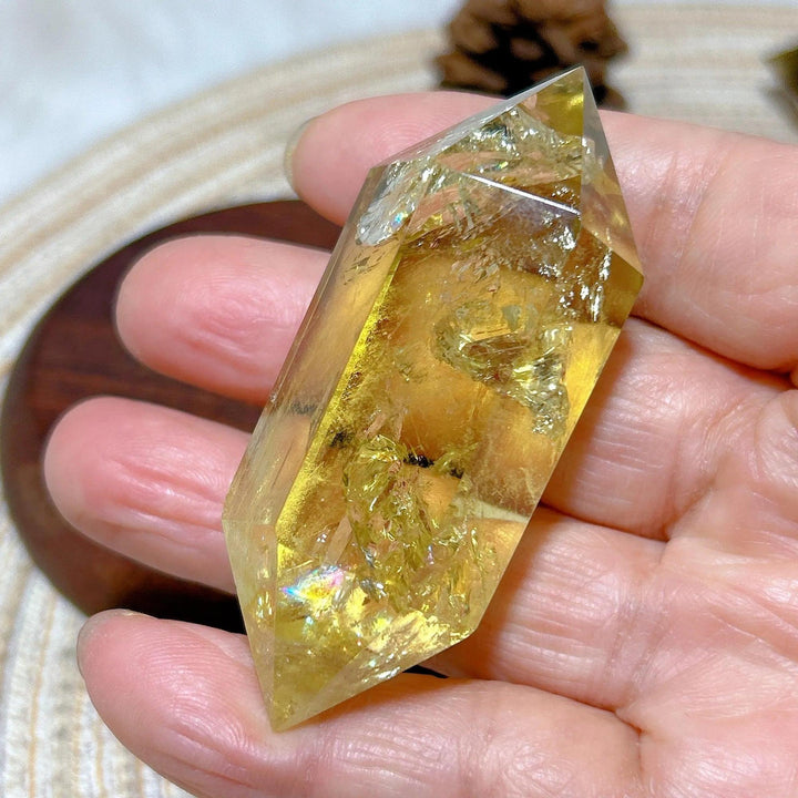 Hand holding a golden Smokey Citrine double tower crystal, ideal for energy healing and home decor.