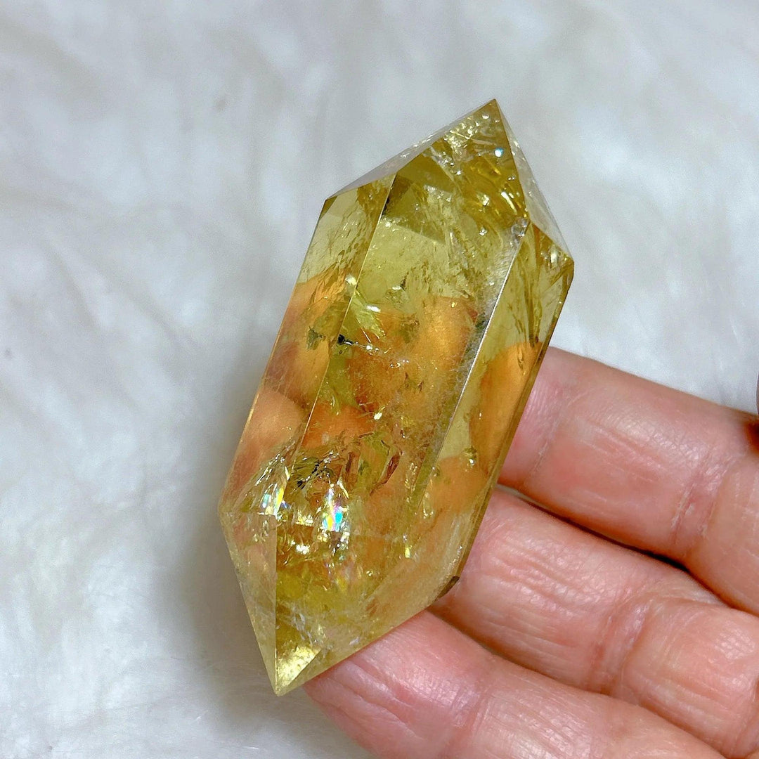Healing natural smokey citrine double tower crystal with golden hues, held in a hand.