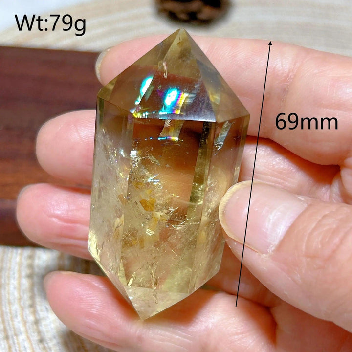 Natural smokey citrine double tower crystal, 69mm, held in hand, showing its golden hue and faceted points.