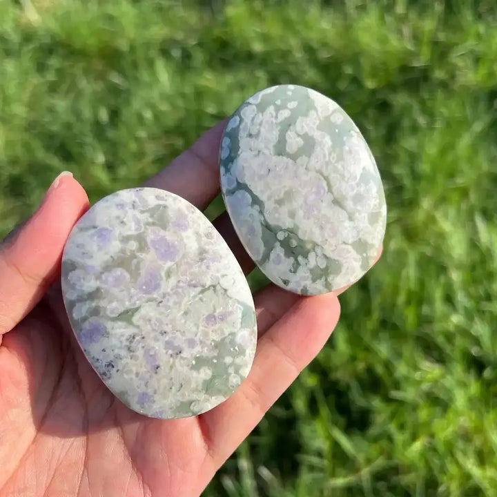 Two polished Natural Snowflake Auspicious Jade palmstones with soothing green and lavender floral patterns for healing.