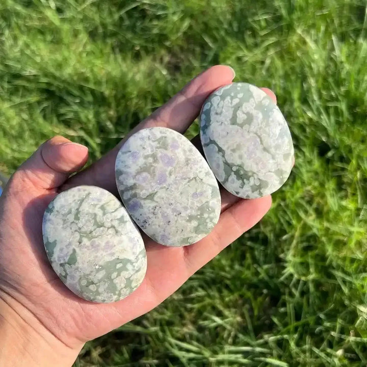 Three smooth, green and purple Natural Snowflake Auspicious Jade palmstones for healing, meditation, and boho decor.
