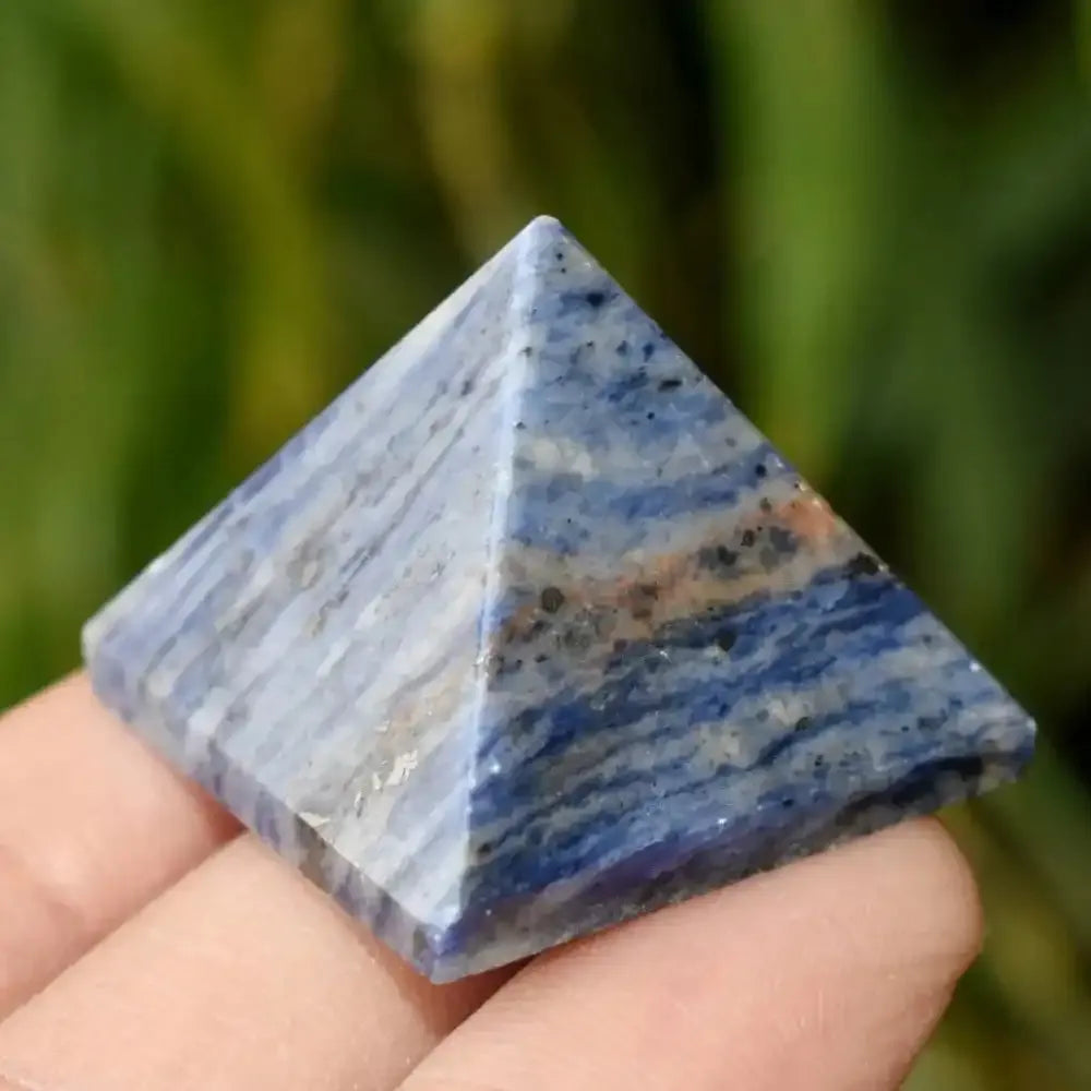 Polished deep blue Sodalite crystal pyramid with natural stone veining, perfect for elegant home decor and healing energy.