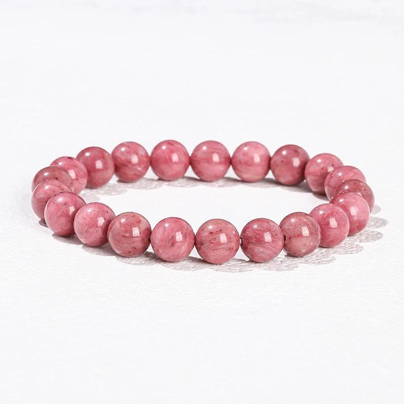 Natural stone beaded bracelet in Rhodonite, featuring smooth, pink heart-chakra gemstone beads on an elastic stretch band.