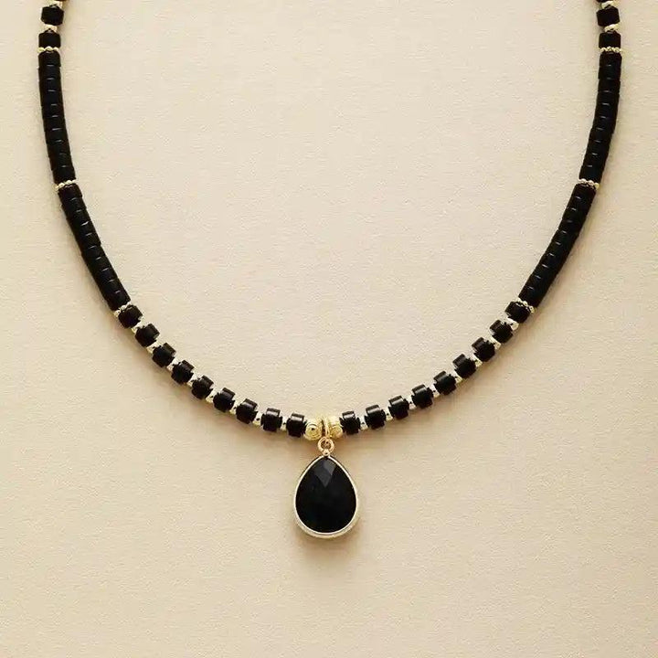 Elegant Natural Stone Teardrop Choker Necklace with black onyx beads and a gold-framed teardrop pendant.